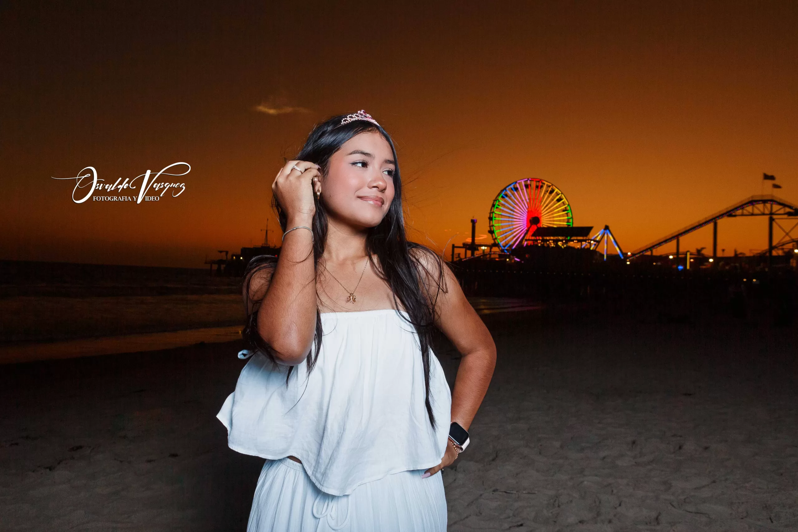 fotografia y video para quinceanera sweet sixteen 4 Quinceanera de Blanco en Santa Monica Atardecer Bajo el cielo anaranjado de Los Ángeles, California, una joven se detiene en la orilla, con la brisa acariciando su cabello y las luces vibrantes del muelle de Santa Mónica brillando a sus espaldas. Foto y Video Huntington Park